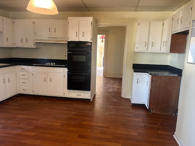 kitchen featuring dark wood-type flooring, a paneled ceiling, black appliances, and white cabinets