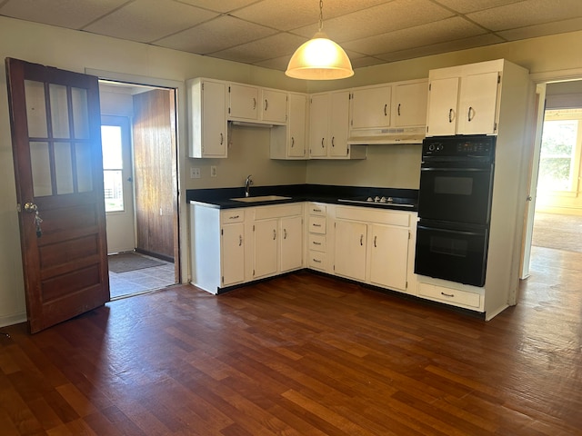 kitchen featuring dark wood-type flooring, white cabinets, and black appliances