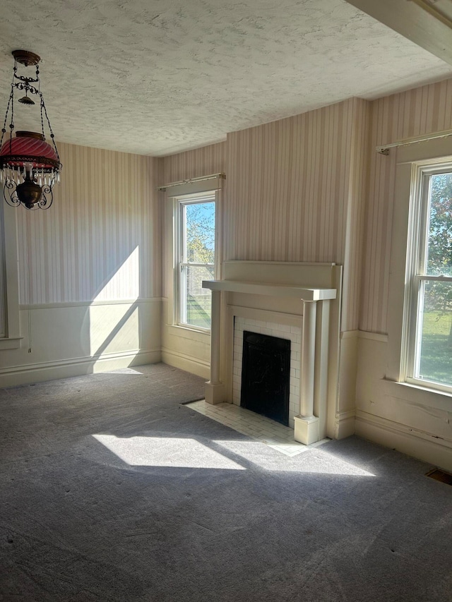 unfurnished living room featuring carpet and a textured ceiling