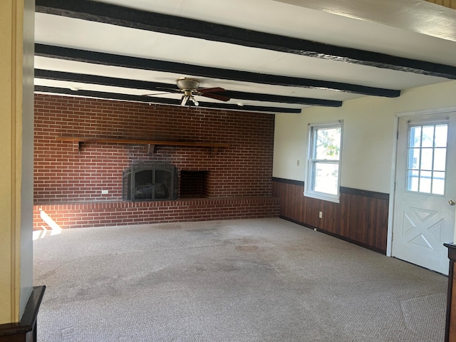 unfurnished living room with beam ceiling, light carpet, and a fireplace