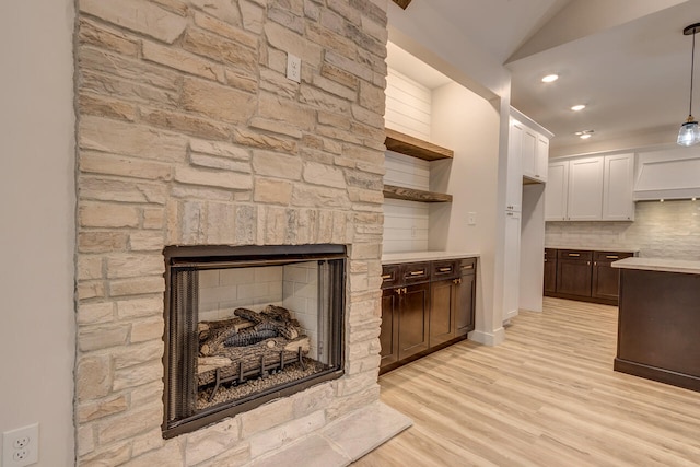 interior details with premium range hood, hardwood / wood-style flooring, a fireplace, and backsplash