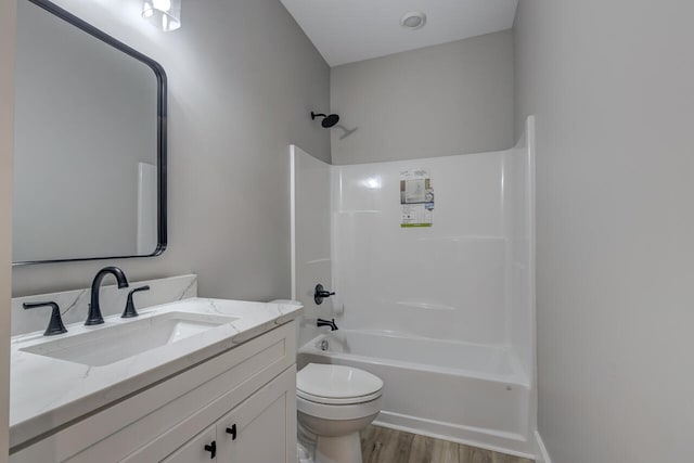 full bathroom with vanity, toilet, wood-type flooring, and  shower combination