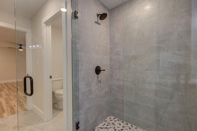 bathroom with ceiling fan, wood-type flooring, toilet, and an enclosed shower