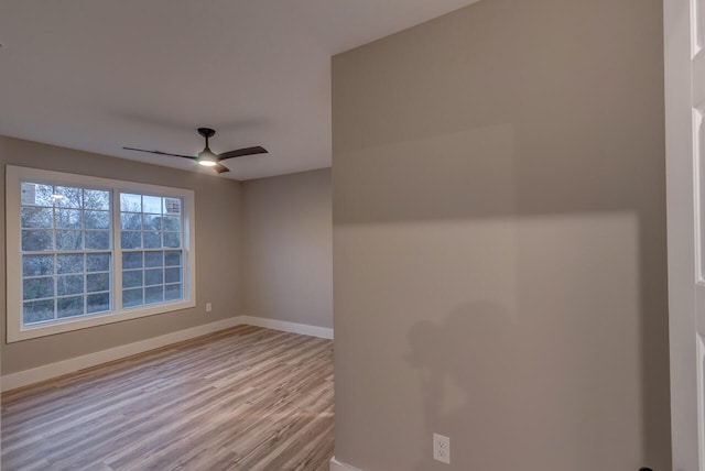 spare room with ceiling fan and light wood-type flooring