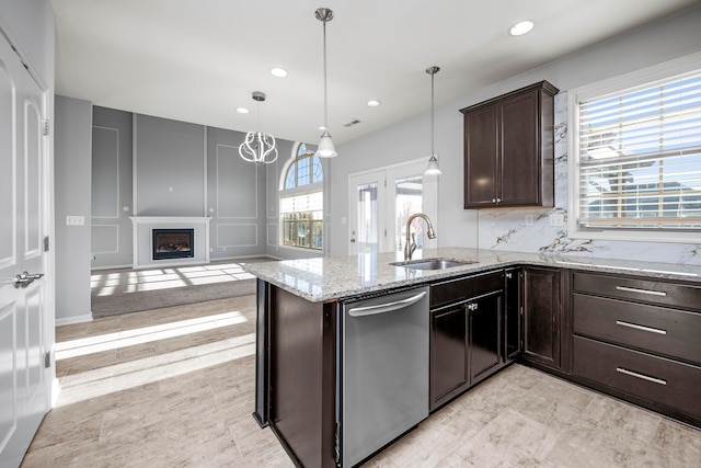 kitchen featuring kitchen peninsula, dishwasher, sink, and hanging light fixtures