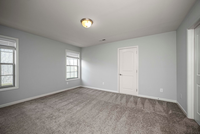 unfurnished room with carpet flooring and a wealth of natural light