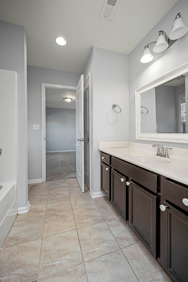 bathroom with vanity, tile patterned flooring, and a bathing tub