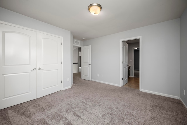 unfurnished bedroom featuring light carpet and a closet