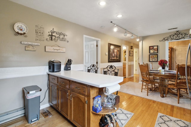 kitchen with light hardwood / wood-style flooring, kitchen peninsula, and rail lighting