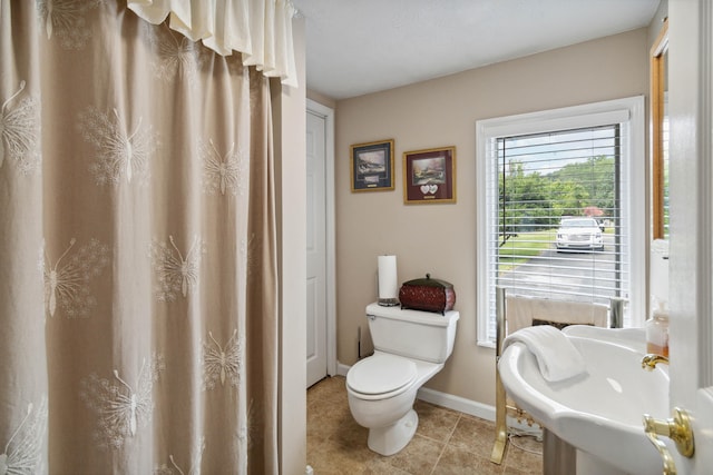 bathroom with sink, toilet, and tile patterned flooring