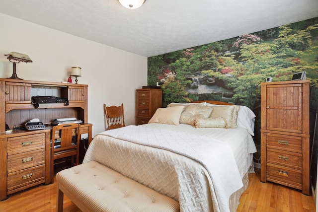 bedroom featuring light hardwood / wood-style floors and a textured ceiling