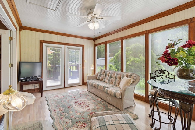 living room featuring light hardwood / wood-style floors, ornamental molding, and ceiling fan