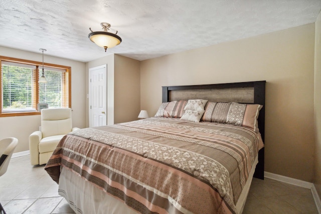 bedroom with a textured ceiling and light tile patterned floors