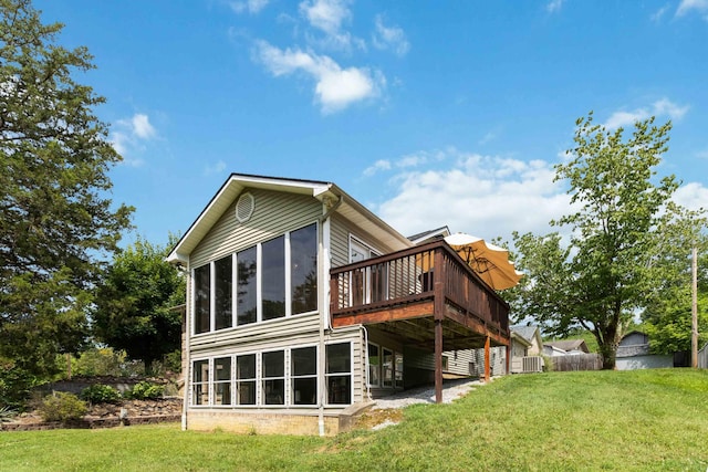 rear view of property featuring central air condition unit, a sunroom, a deck, and a lawn