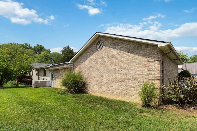 view of side of property featuring a deck and a lawn