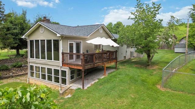 back of house featuring a yard, a wooden deck, and a sunroom