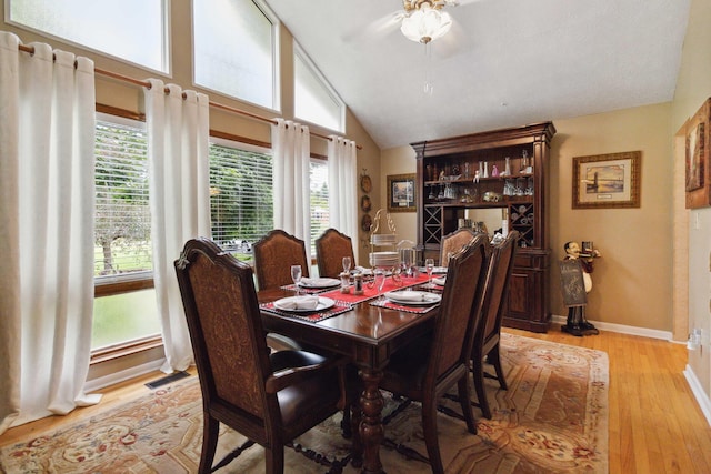 dining room featuring light wood-type flooring, lofted ceiling, plenty of natural light, and ceiling fan