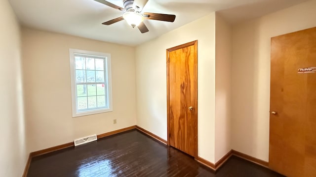 unfurnished bedroom featuring dark wood-type flooring and ceiling fan