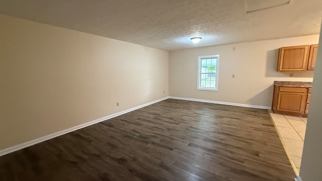 spare room featuring a textured ceiling and wood-type flooring