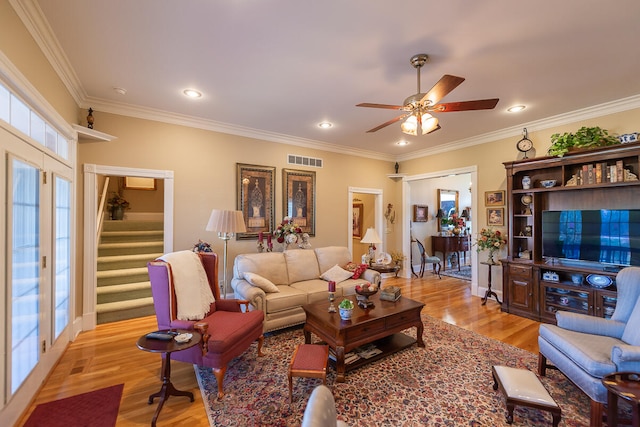 living room with ornamental molding, light hardwood / wood-style floors, and ceiling fan