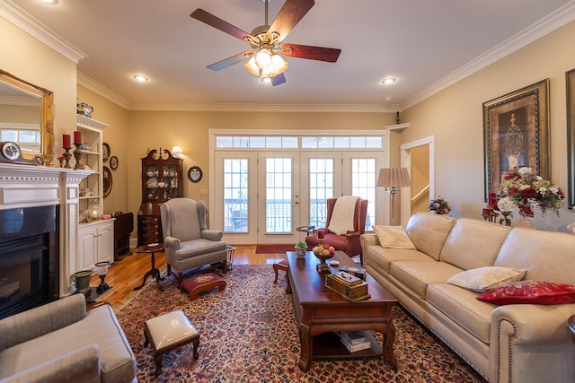 living room featuring ceiling fan, wood-type flooring, and ornamental molding