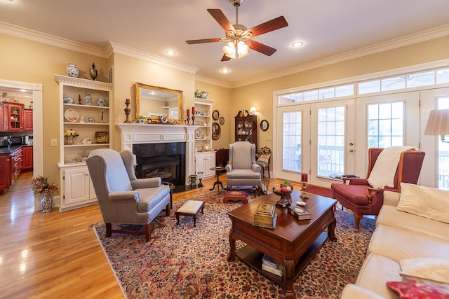 living room with ornamental molding, light hardwood / wood-style floors, and ceiling fan