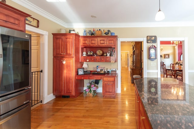 kitchen with stainless steel double oven, light hardwood / wood-style floors, decorative light fixtures, dark stone countertops, and ornamental molding