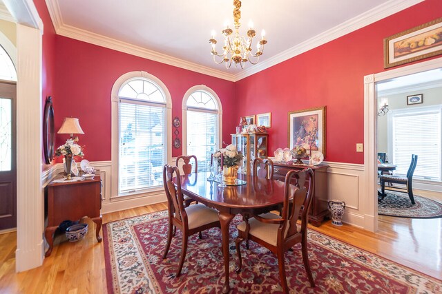 dining area featuring ornamental molding, a chandelier, and wood-type flooring