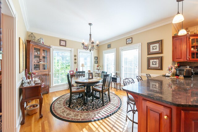 dining area featuring a wealth of natural light, crown molding, light hardwood / wood-style flooring, and a chandelier