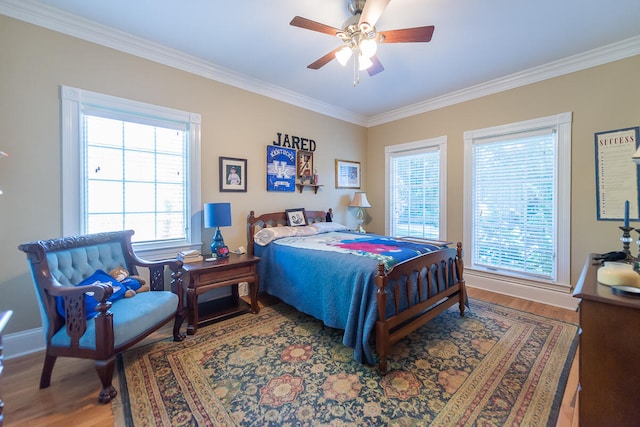 bedroom with ceiling fan, crown molding, and wood-type flooring