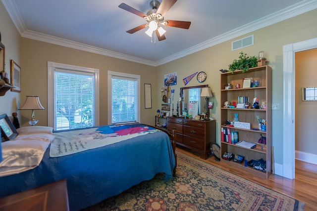 bedroom featuring ceiling fan, ornamental molding, and hardwood / wood-style floors