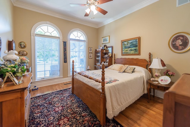 bedroom with crown molding, hardwood / wood-style flooring, and ceiling fan