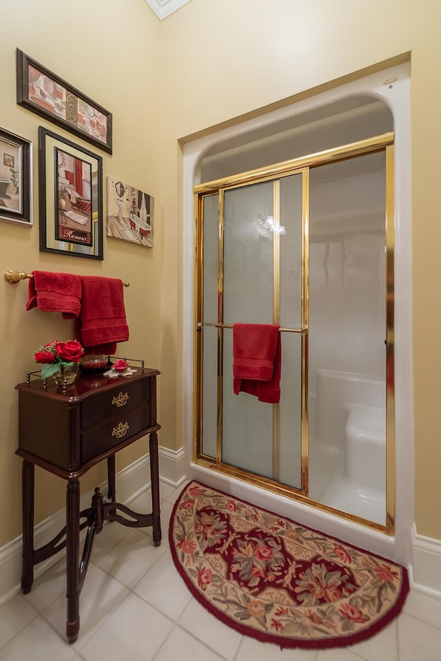 bathroom with a shower with door and tile patterned floors