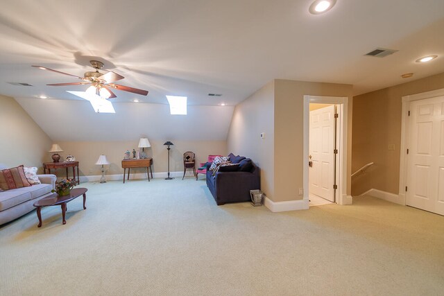 carpeted living room featuring lofted ceiling with skylight and ceiling fan