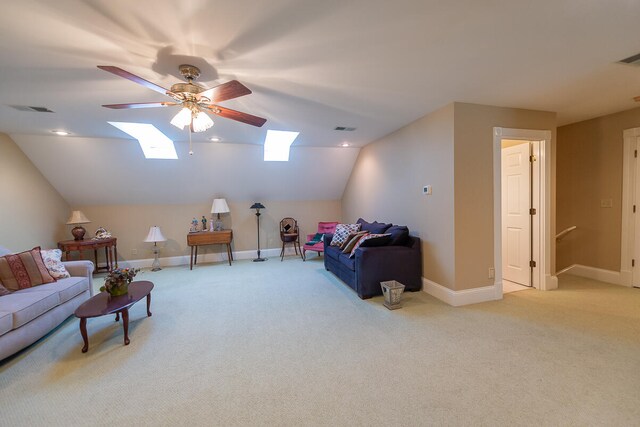 living room featuring light carpet, lofted ceiling with skylight, and ceiling fan