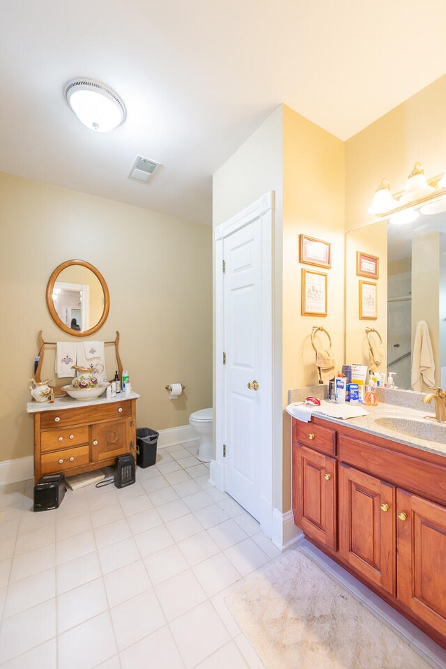 bathroom with vanity, toilet, tile patterned floors, and a shower with shower door