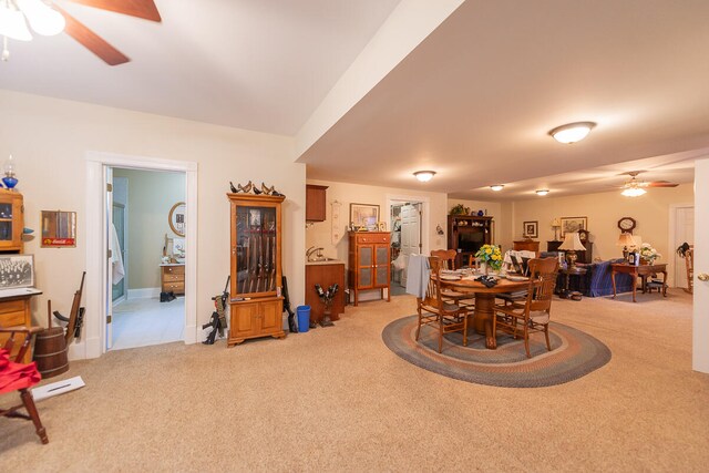 carpeted dining space with ceiling fan