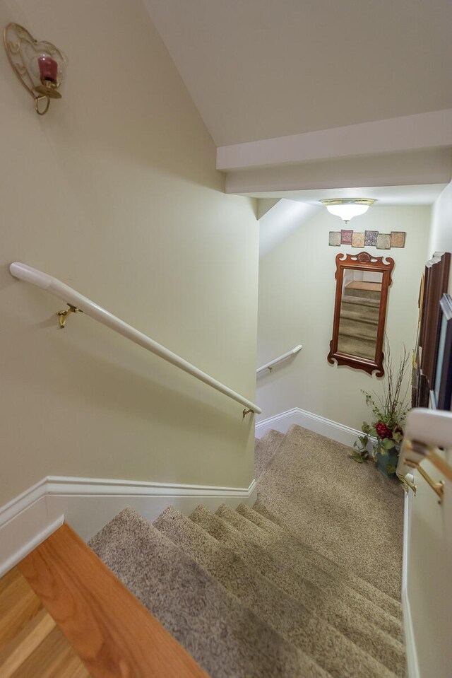 stairway featuring lofted ceiling