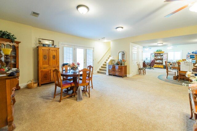 carpeted dining space with ceiling fan