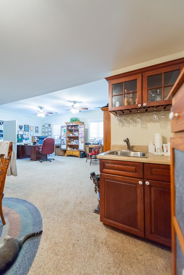 interior space featuring ceiling fan, sink, and light colored carpet