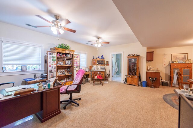 carpeted home office featuring ceiling fan and a healthy amount of sunlight