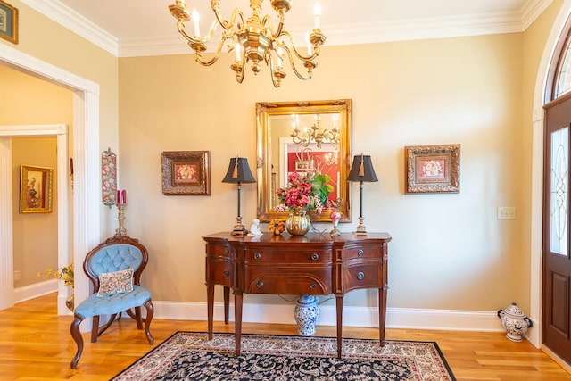 foyer with an inviting chandelier, light hardwood / wood-style flooring, and crown molding