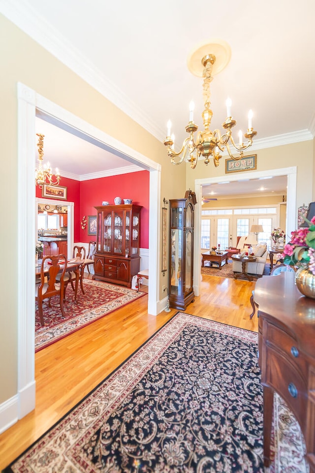 interior space with ornamental molding, a notable chandelier, and wood-type flooring