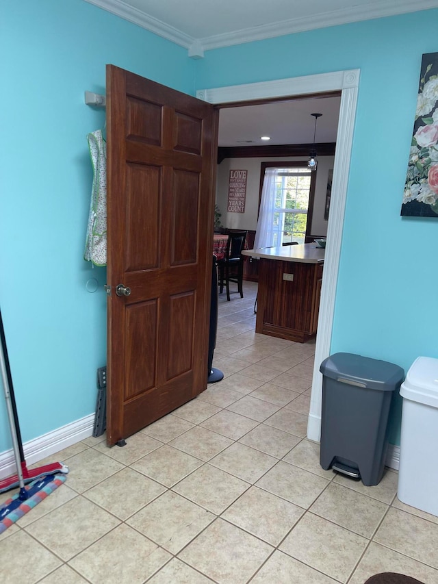 hall featuring ornamental molding and light tile patterned floors