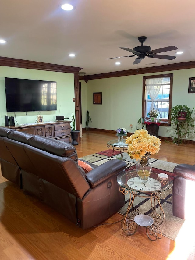 living room featuring ornamental molding, light wood-type flooring, and ceiling fan