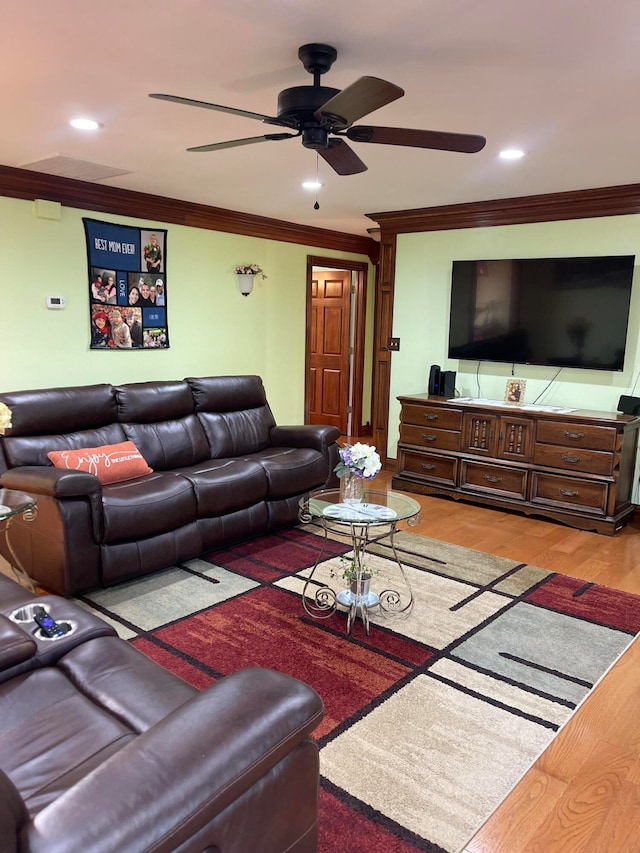 living room with crown molding, light wood-type flooring, and ceiling fan