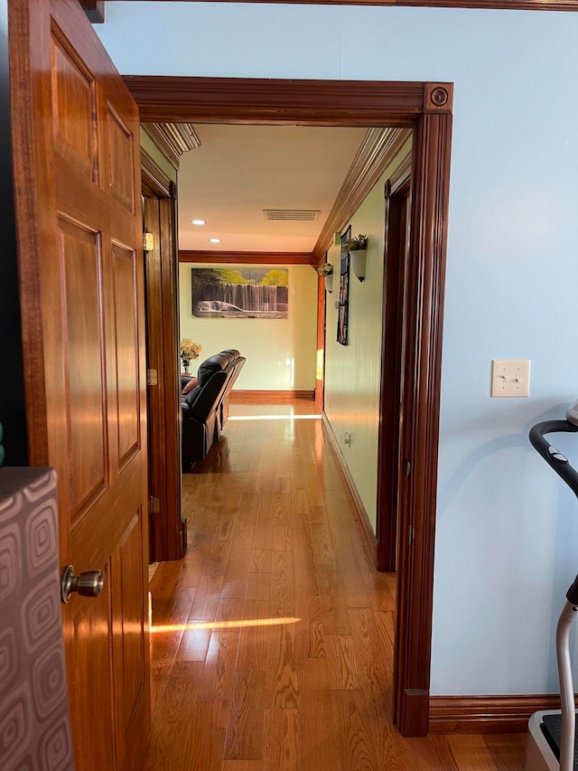 corridor featuring ornamental molding and hardwood / wood-style floors