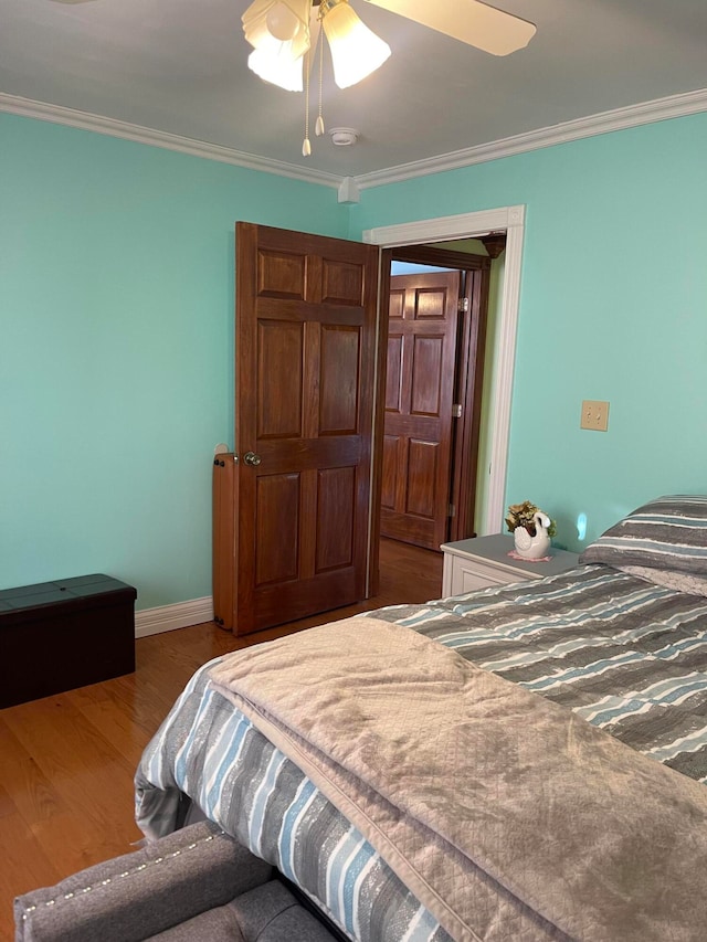 bedroom featuring ornamental molding, wood-type flooring, and ceiling fan