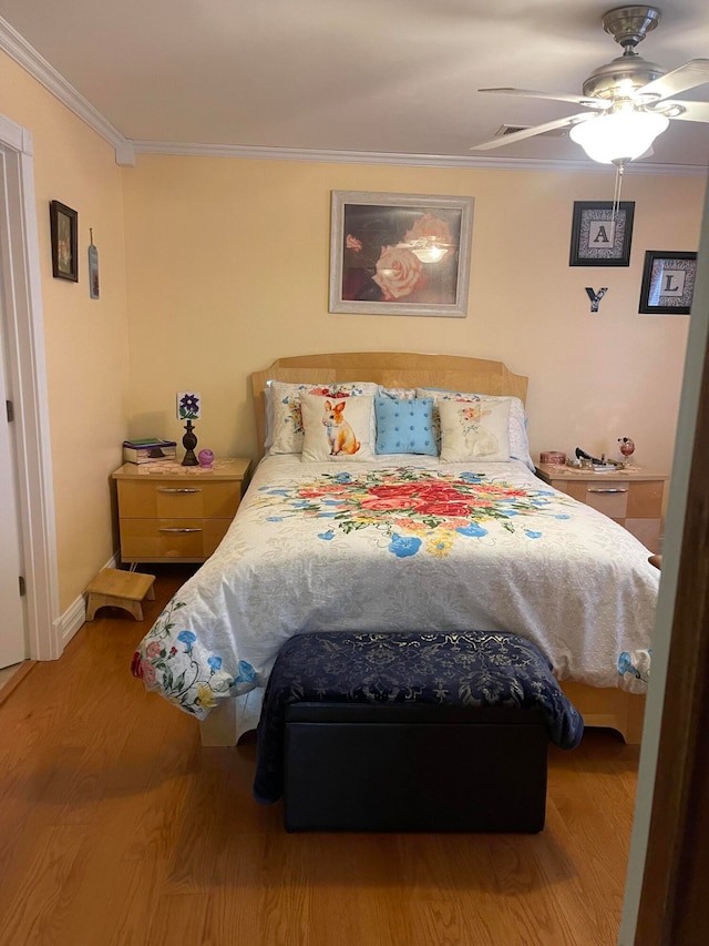 bedroom with crown molding, light hardwood / wood-style flooring, and ceiling fan