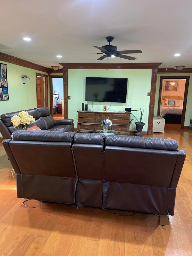 living room featuring ornamental molding, ornate columns, light wood-type flooring, and ceiling fan